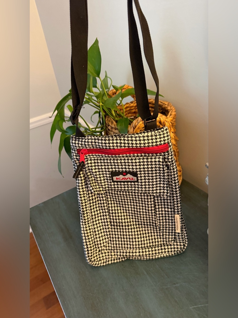 KAVU limited edition houndstooth crossbody bag with bright red zipper.